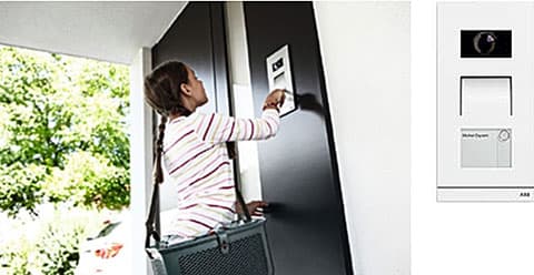 Tyttö käyttää ABB Welcome -ovipuhelinta