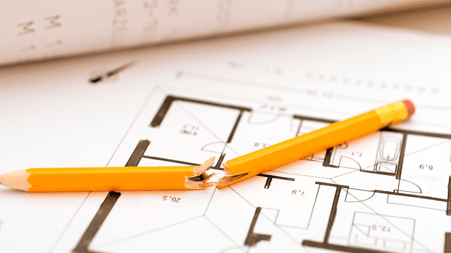 poikki taitettu lyijykynä talosuunnitelman päällä