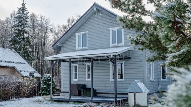 vaalea omakotitalo pääty kohti kameraa hieman lumisessa maisemassa
