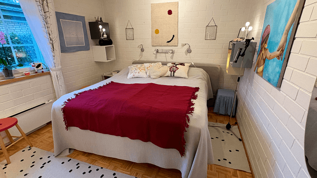 valkoinen makuuhuone ja punainen torkkupeitto sängyllä