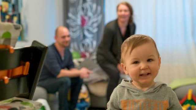 Perhe istuu olohuoneessa